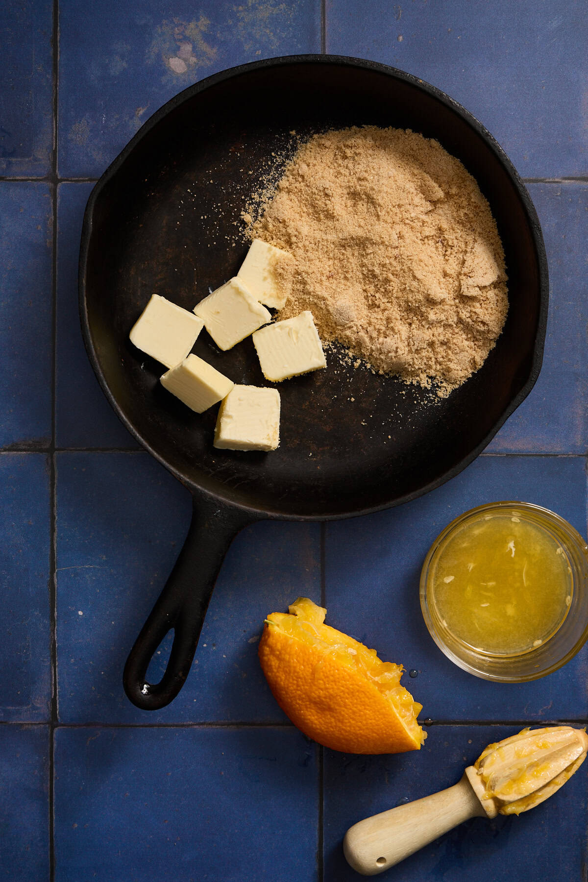 butter and brown sugar melting in a pan with a juiced oranged