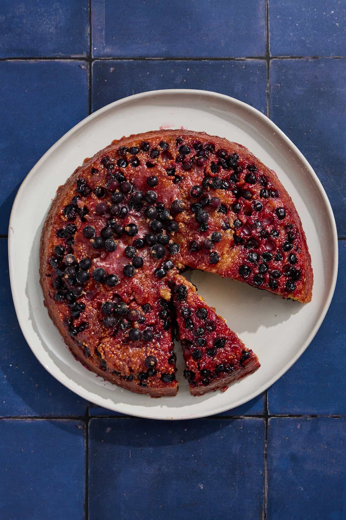 a blackcurrant cake on a plate with a piece cut