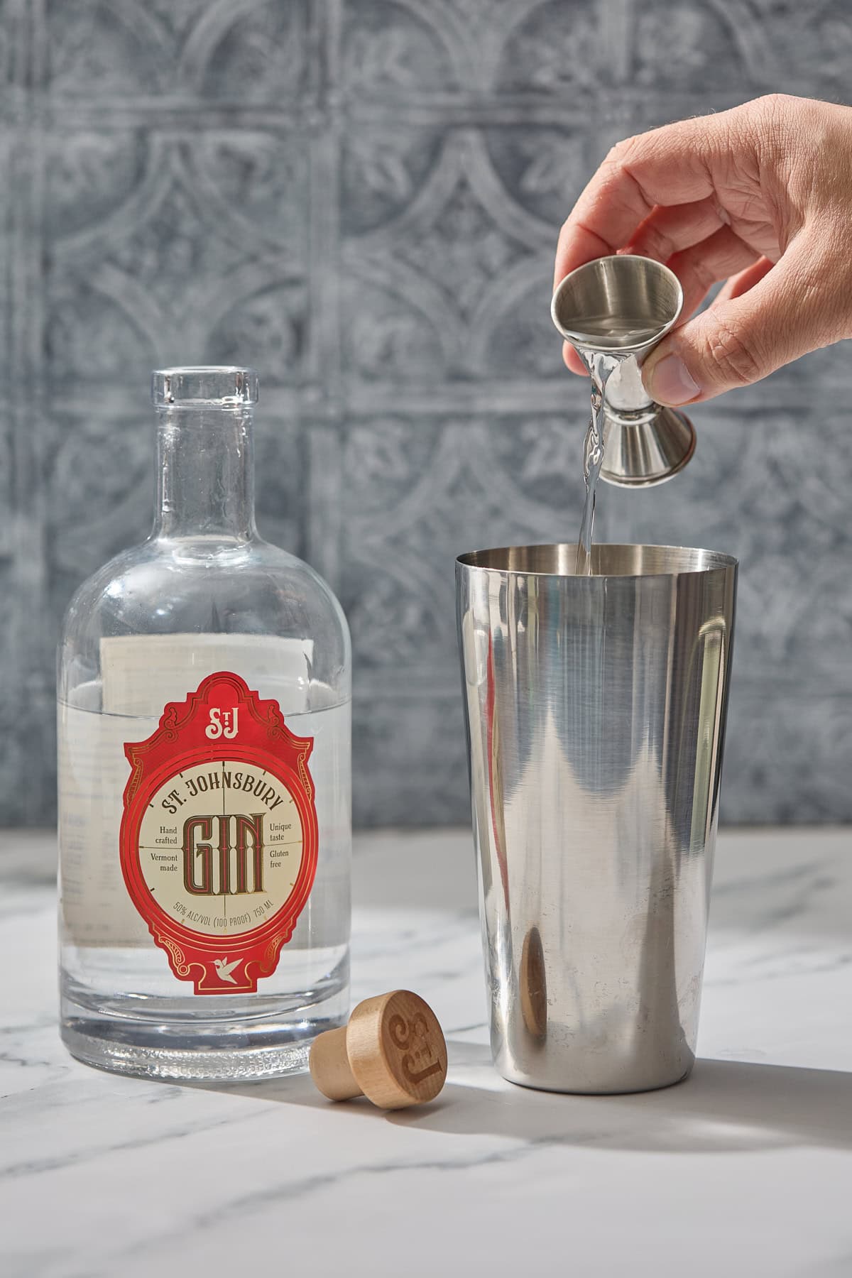 gin being poured into a cocktail shaker