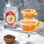 two glasses of gin and earl grey tea cocktail with tea and gin bottle