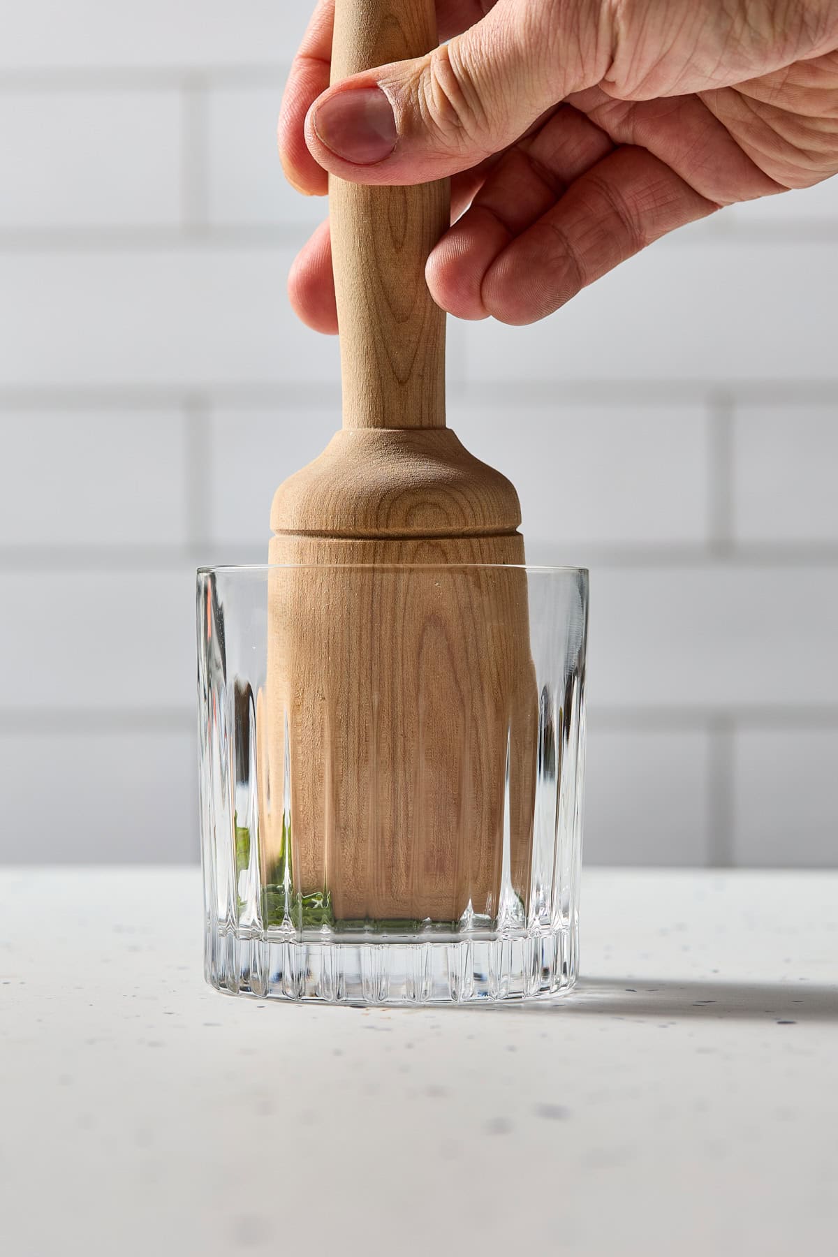 fresh mint being muddled in a glass