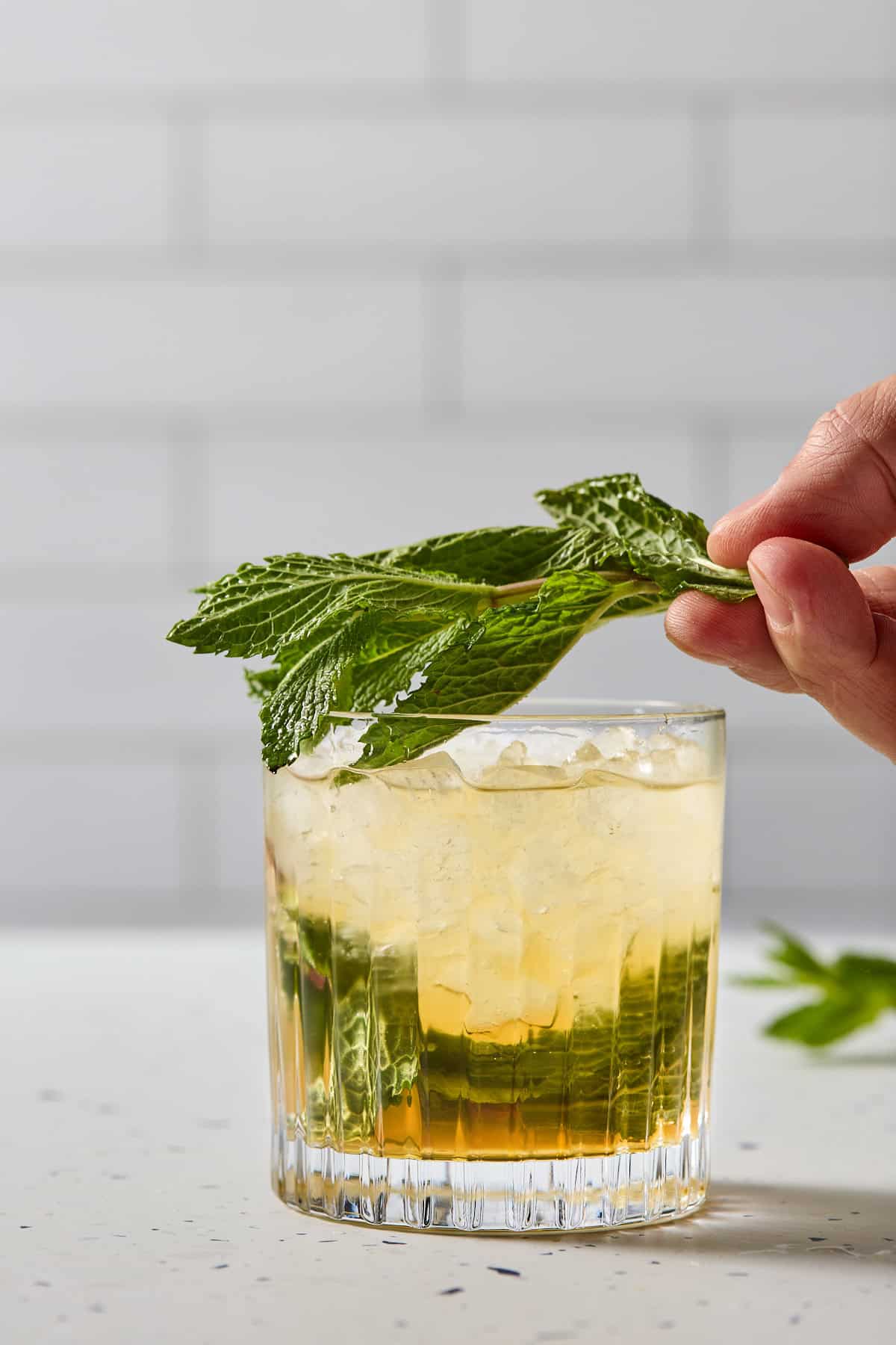 mint being whacked over the mocktail