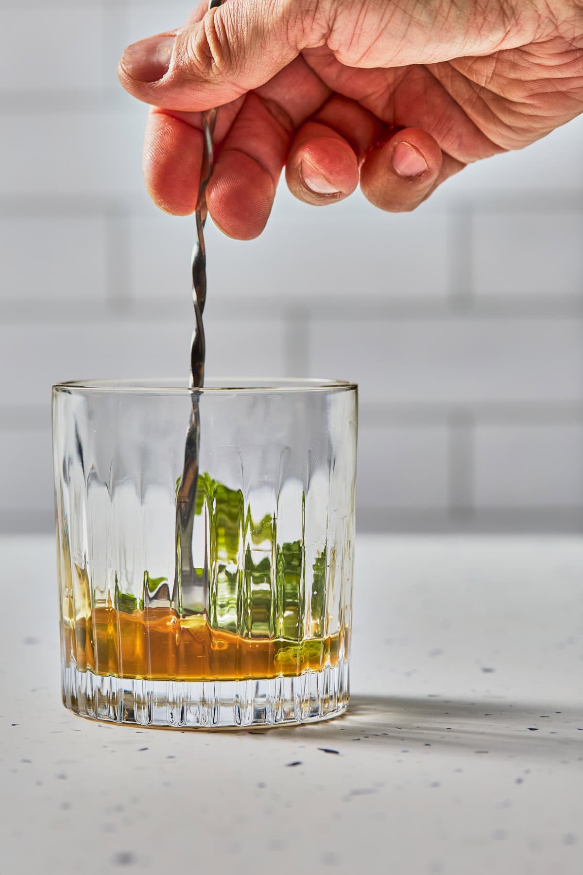 cocktail ingredient being stirred in a glass