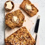 sliced banana and rhubarb bread on a cutting board with butter