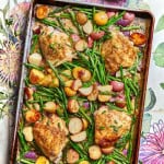 a tray of raosted chicken with asparagus and potatoes