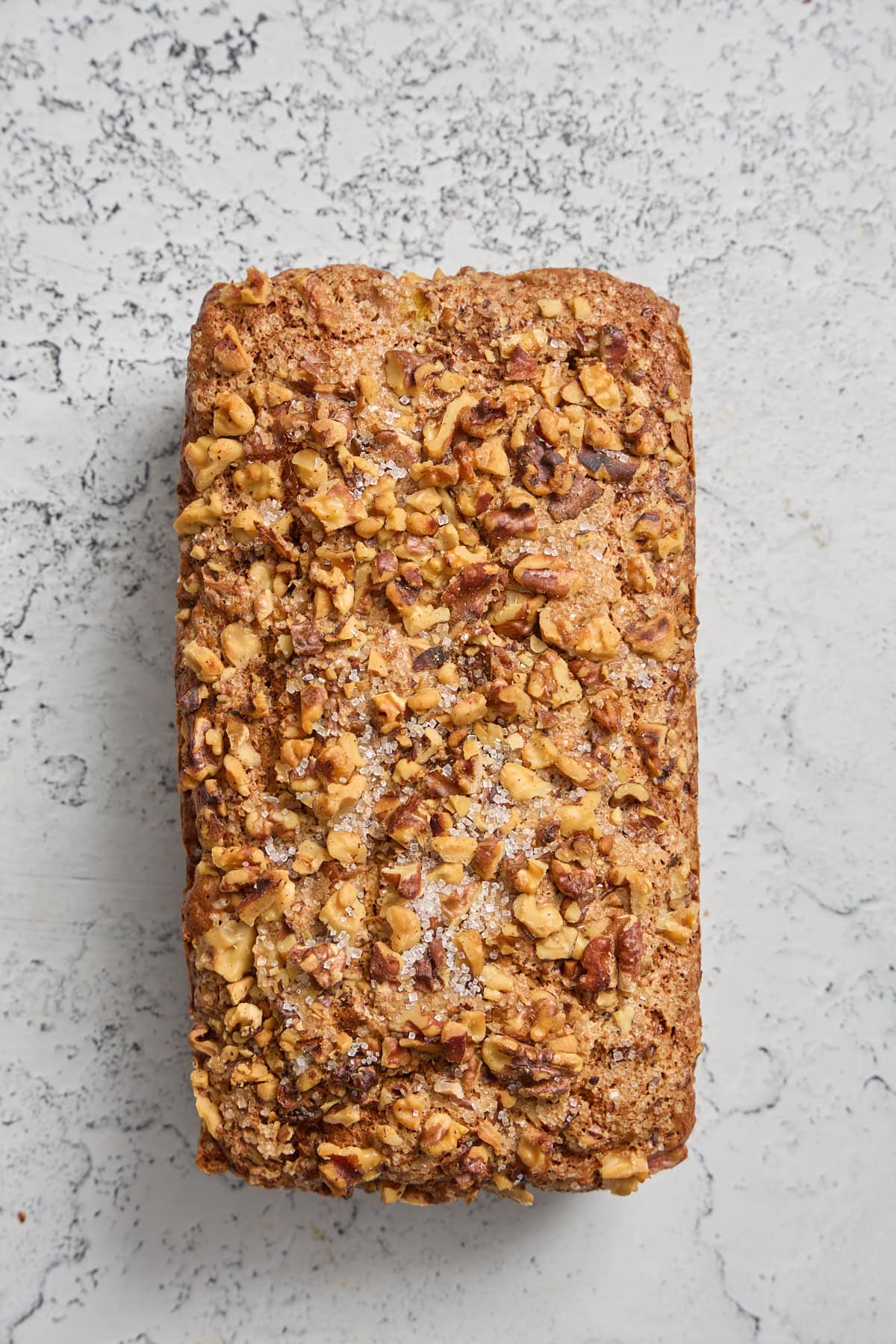 a loaf of rhubarb banana bread with walnuts on a counter