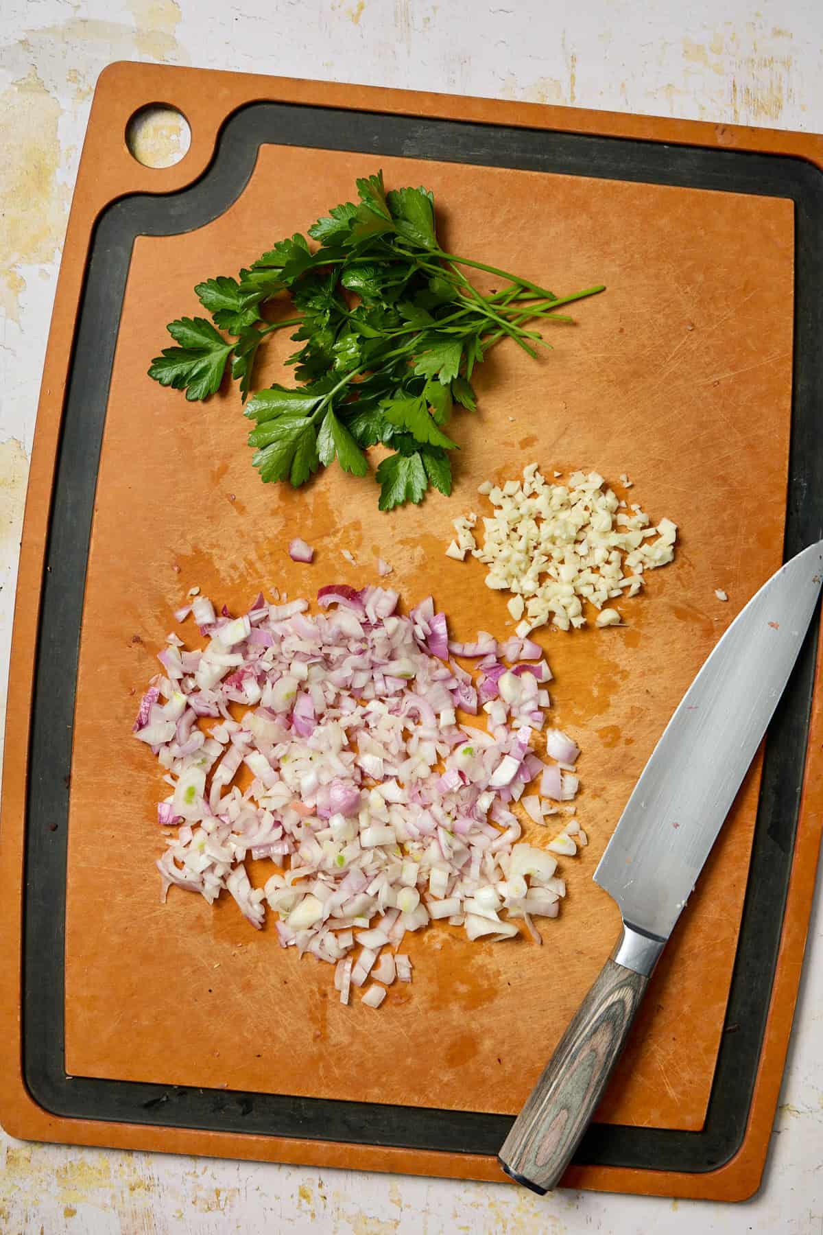 chopped shallots, garlic, and herbs on a cutting board
