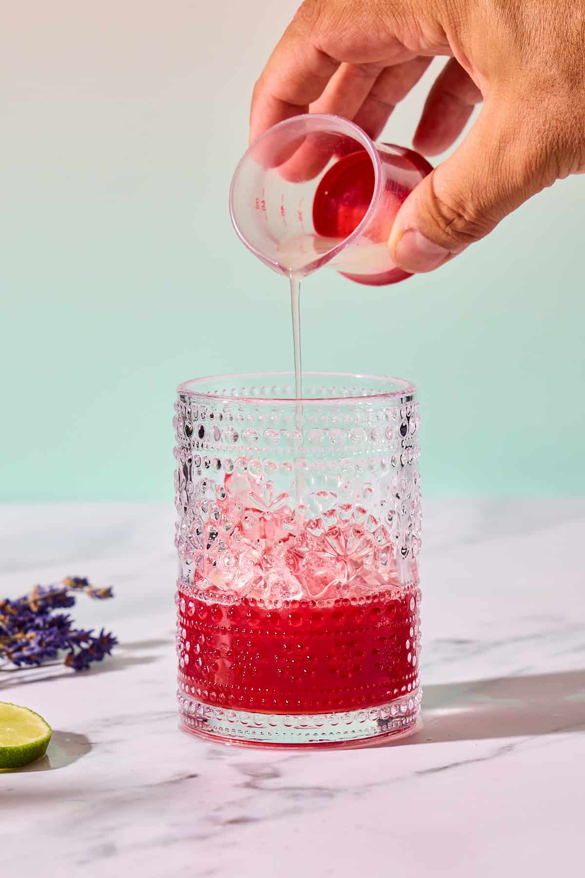 lime juice being poured into glass of mocktail