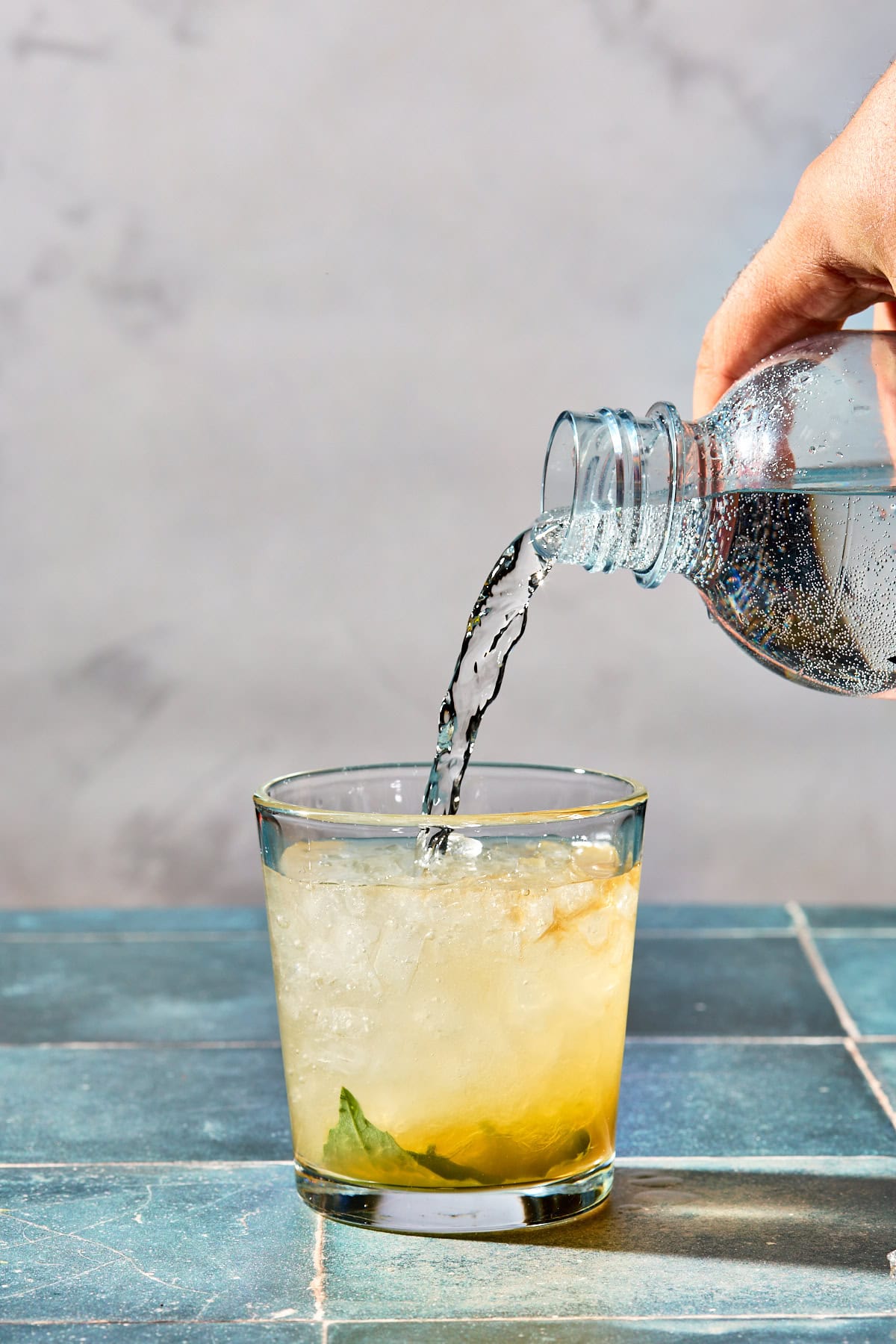 sparkling water being poured into the cocktail glass