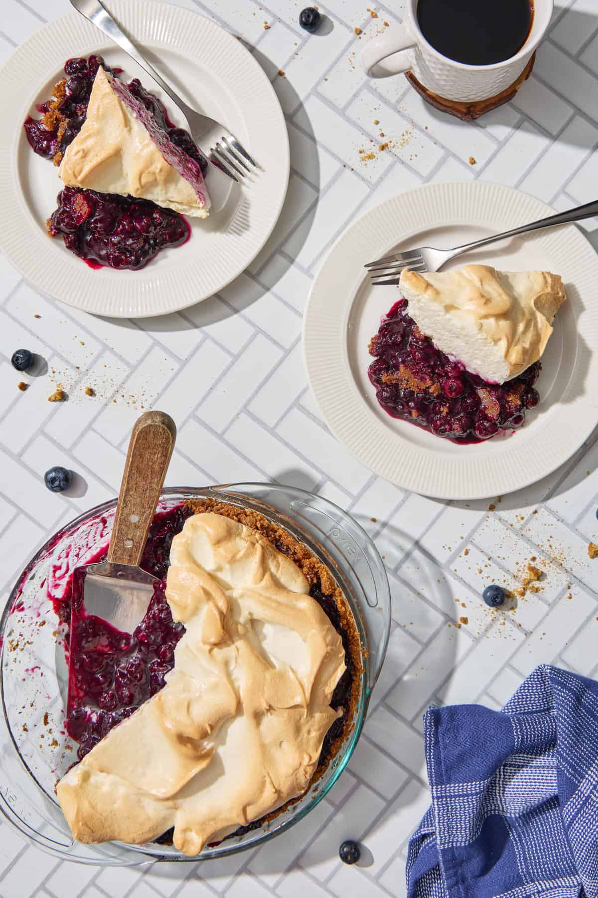 slices of blueberry pie with meringuye on plates with blueberries