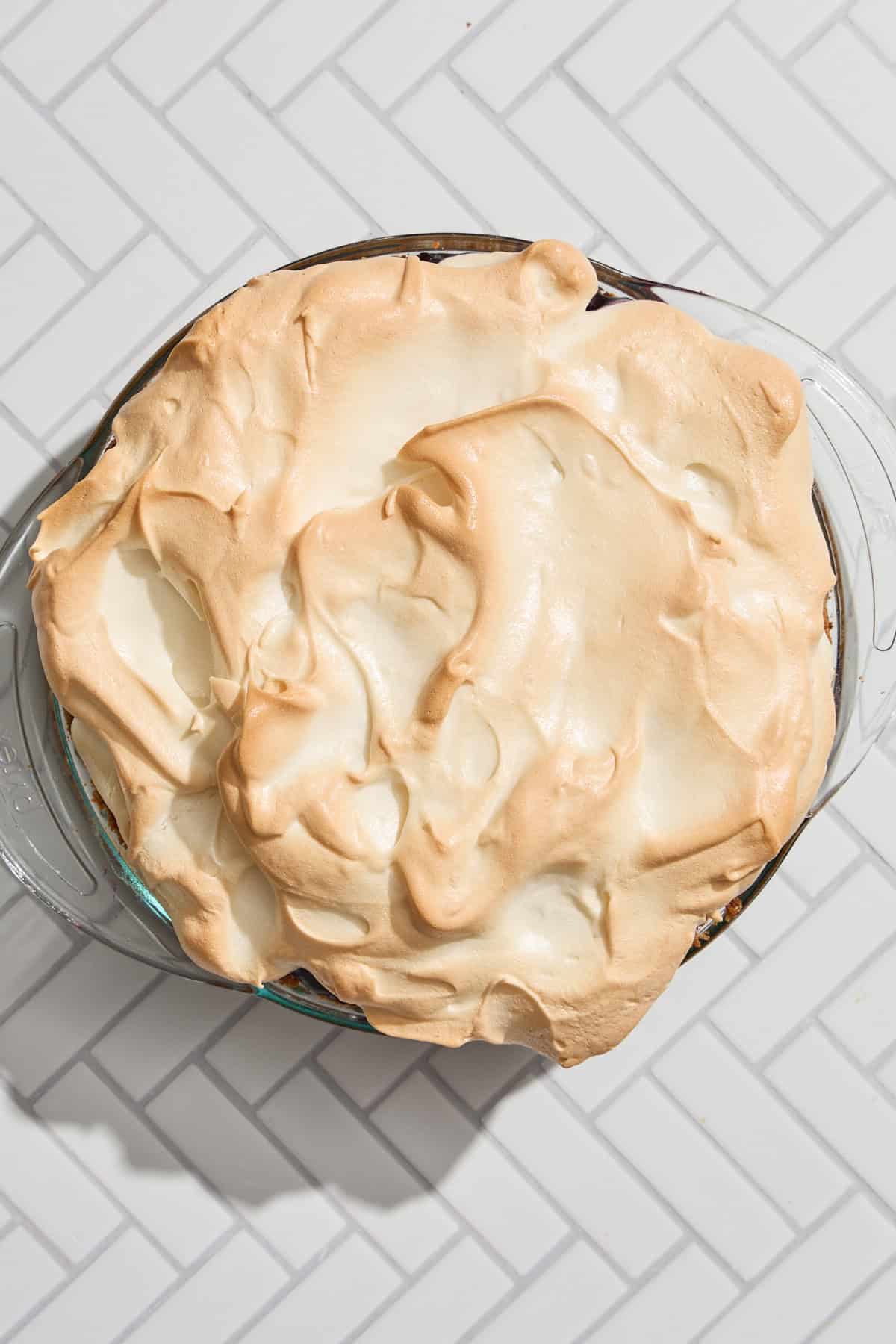 a pie topped with browned meringue sitting on a counter