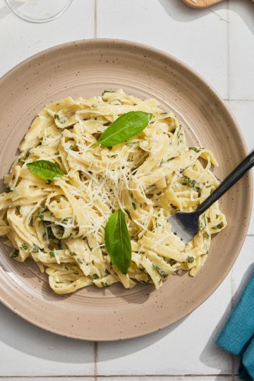 a dish of creamy pasta with basil and cheese