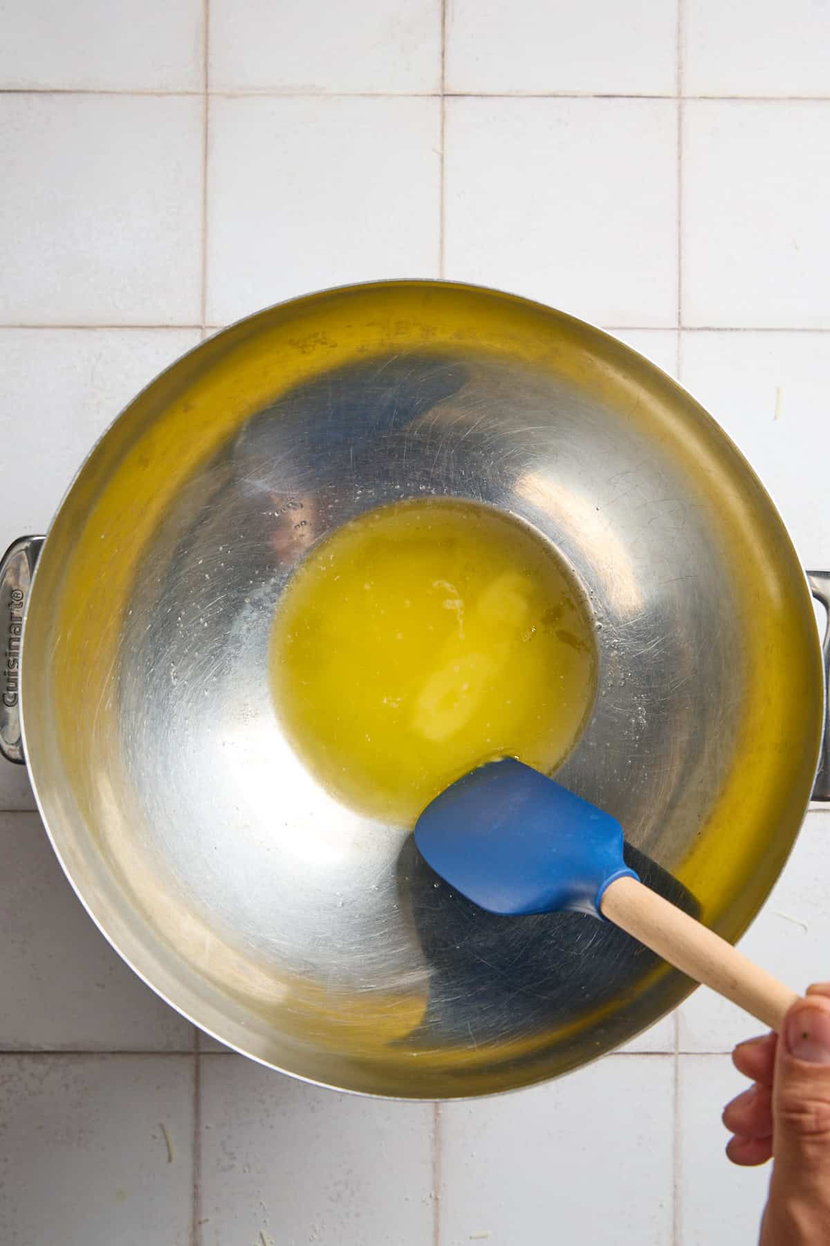 a large metal bowl with melted butter and a spatula
