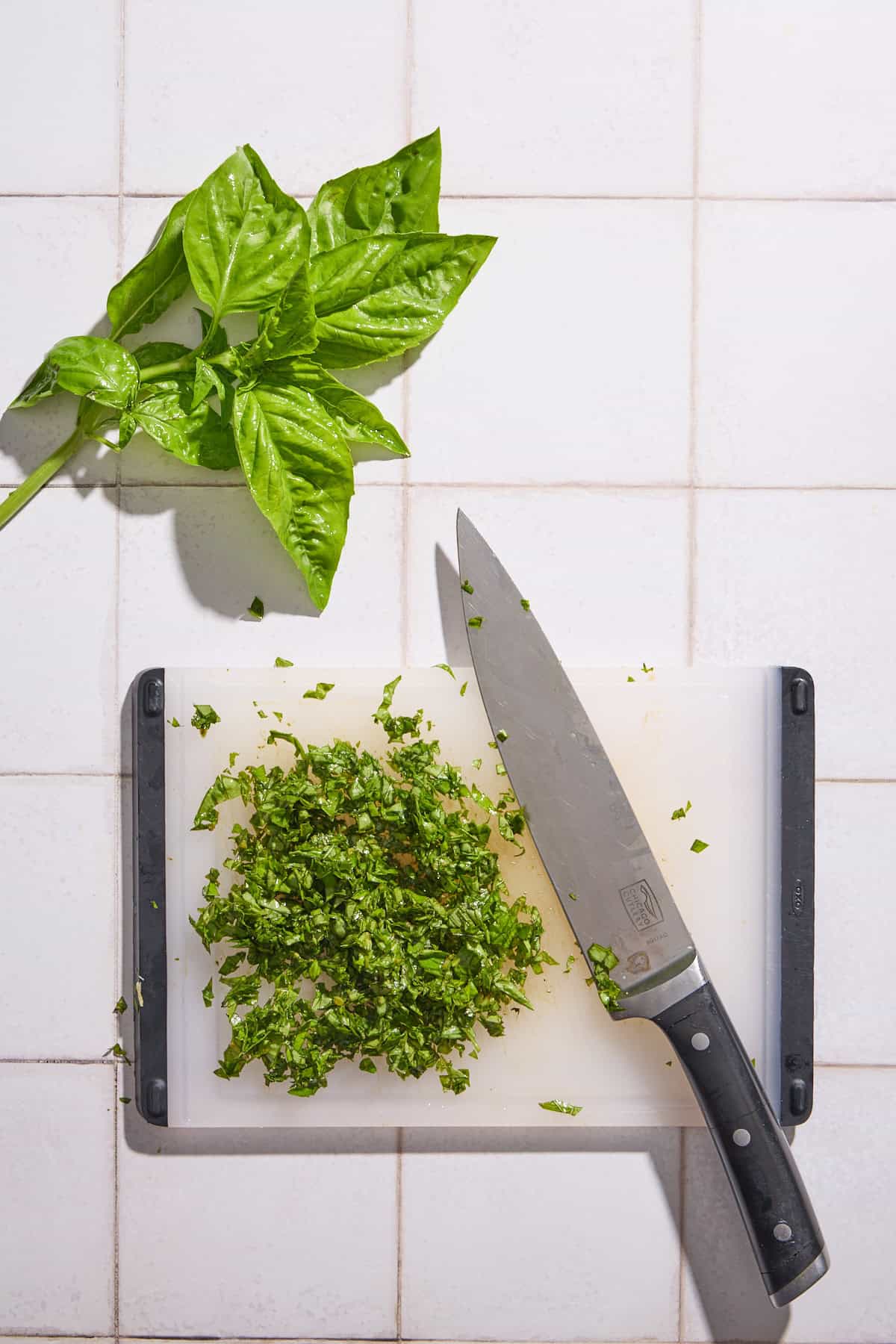 basil chopped on a cutting board with a knife