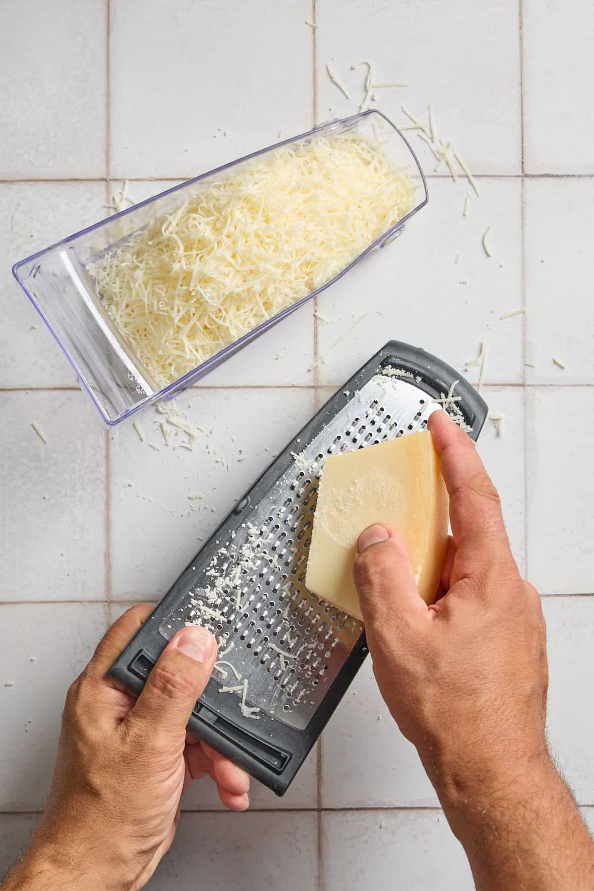 a block of parmesan cheese being grated on a grater